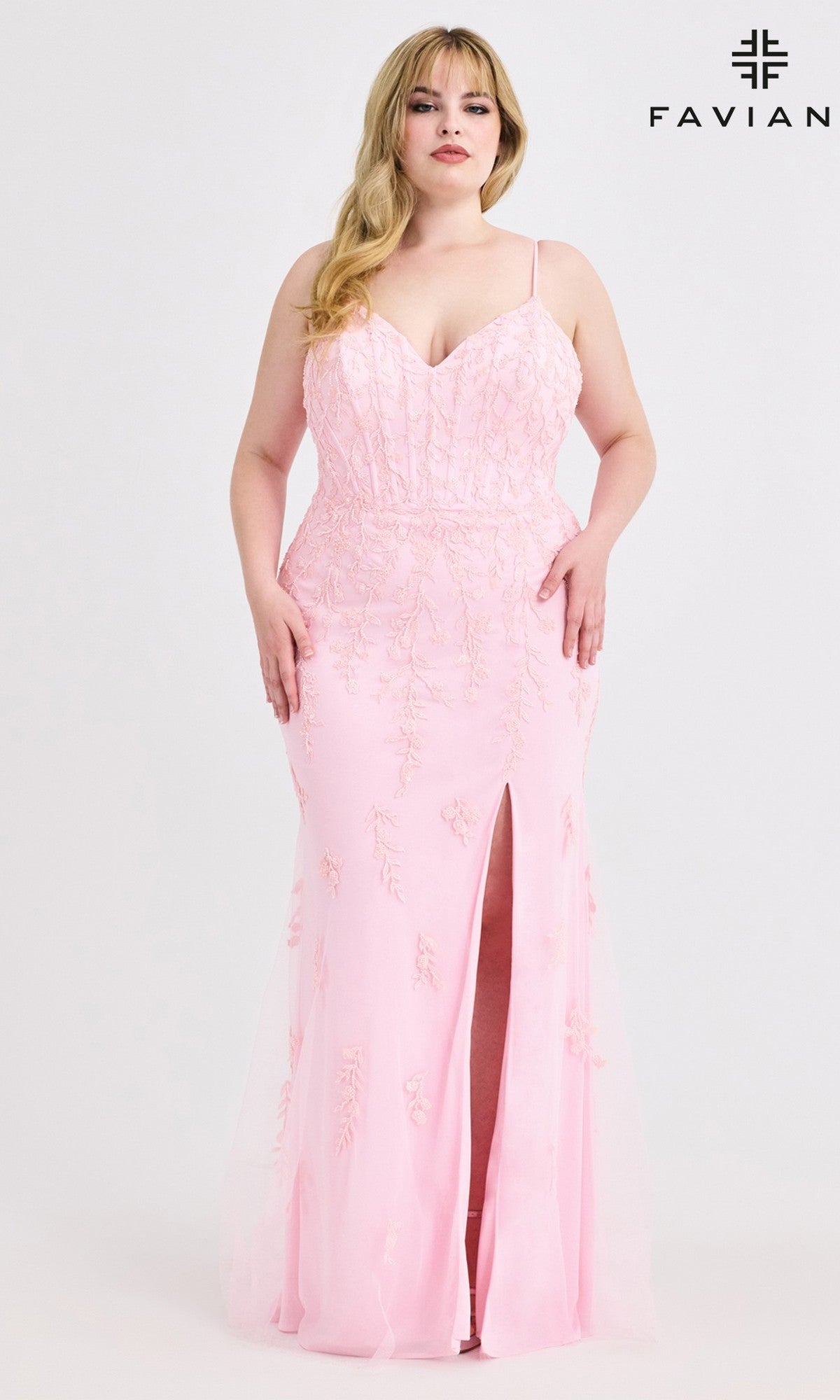 A woman wears the Plus-Size Beaded-Lace Prom Gown, Faviana 9604—a light pink, sleeveless long dress with beaded-lace appliques and a front slit—posing against a white background with